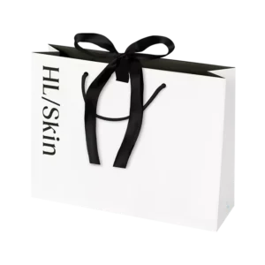Bolsa de regalo pequeña HL/Skin blanca con lazo negro, ideal para presentar productos de cuidado de la piel